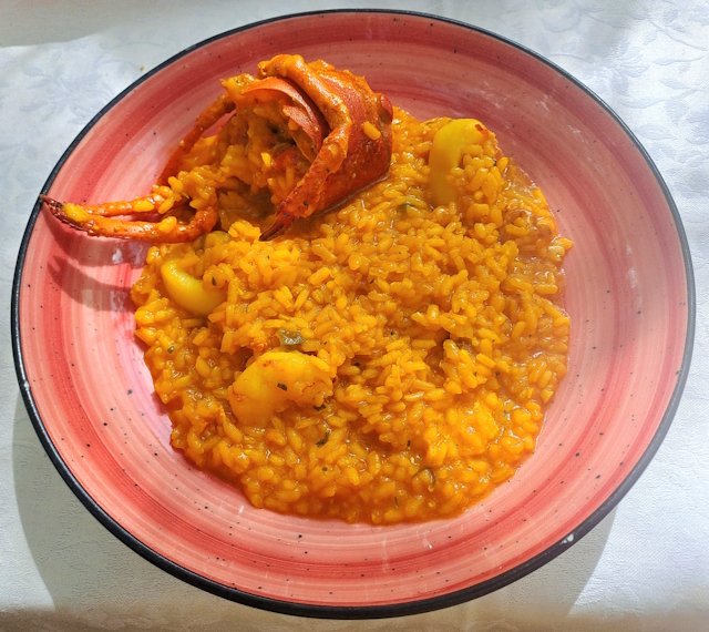 Plato de arroz meloso de bogavante servido en un plato